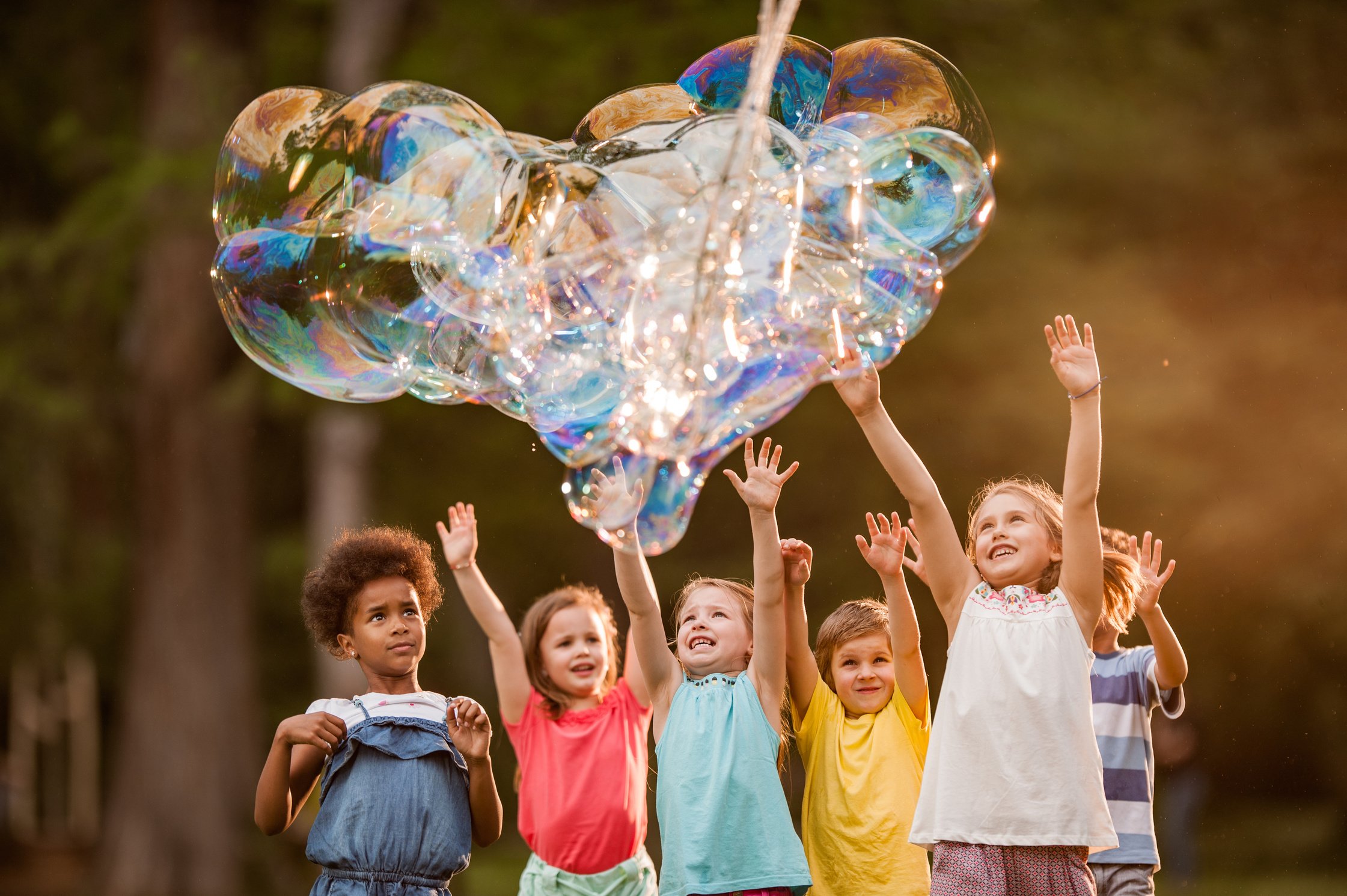 Happy kids and heart shaped rainbow bubbles!